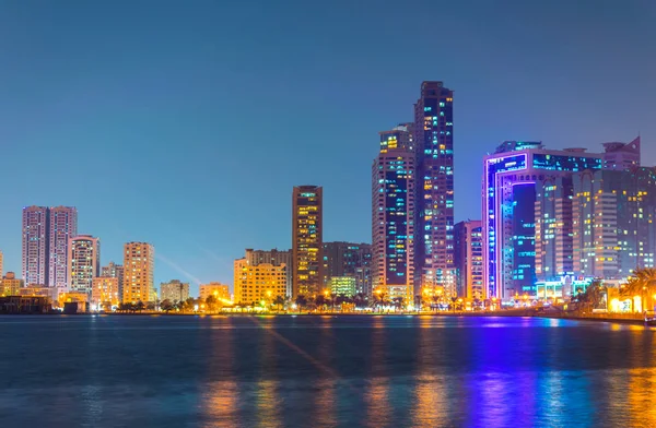 Sunset view of the Khalid lagoon surrounded with skyscraper in the emirate Sharjah, UAE — Stock Photo, Image