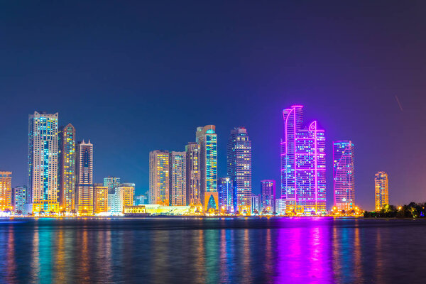 Skyscrapers surrounding the Al Majaz amphitheater situated on an artificial island in Sharjah during night, UAE