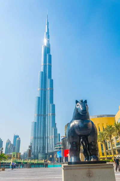 Estátua de um cavalo gordo em frente ao arranha-céu Burj Khalifa em Dubai, Emirados Árabes Unidos — Fotografia de Stock