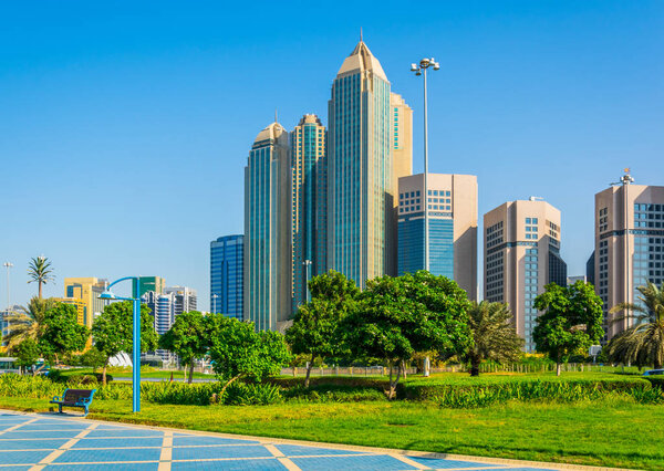 View of a corniche in Abu Dhabi stretching alongside the business center full of high skyscrapers.