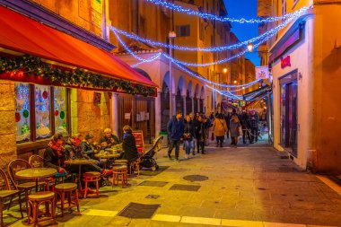 Nice, Fransa, 28 Aralık 2017: Nice, Fransa'nın merkezindeki dar bir sokakta insanların gece manzarası dolaşıyor