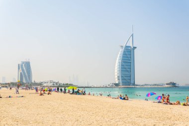 Dubai, Bae, 26 Ekim 2016: İnsanlar Dubai, Bae'deki Burj al Arab otelinin önündeki plajda güneşli bir günün tadını çıkarıyorlar