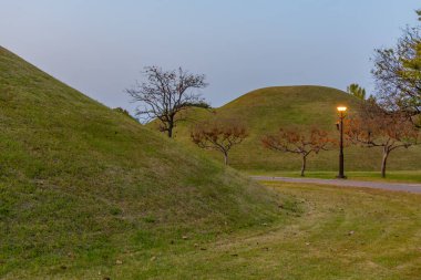 Kore Cumhuriyeti 'nin Gyeongju şehrinde bulunan birkaç kraliyet mezarının bulunduğu Tumuli parkının günbatımı manzarası.