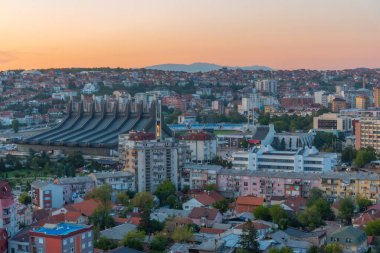 Kosova 'daki Gençlik ve Spor Sarayı ile Prishtina' nın manzarası için gün batımı