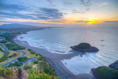 Yeni Plymouth yakınlarındaki Paritutu kayasından Yeni Zelanda kıyılarının günbatımı görüntüsü