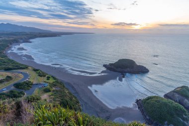 Yeni Plymouth yakınlarındaki Paritutu kayasından Yeni Zelanda kıyılarının günbatımı görüntüsü
