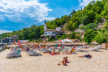 BALCHIK, BULGARIA, 13 Temmuz 2019: Bulgaristan 'ın Balchik kentindeki bir plajda güneşli bir günün tadını çıkarıyorlar