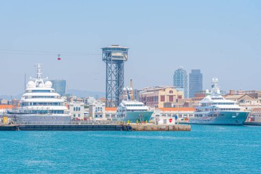 İspanya, Barcelona Limanı 'ndaki lüks yatların üstündeki kablolu araba.