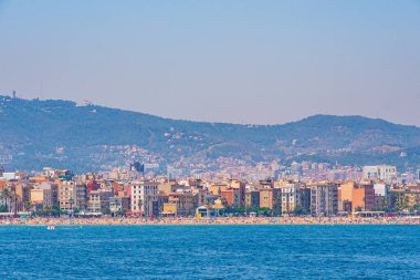İnsanlar Barcelona, İspanya 'daki Barceloneta plajında güneşli bir günün tadını çıkarıyorlar.