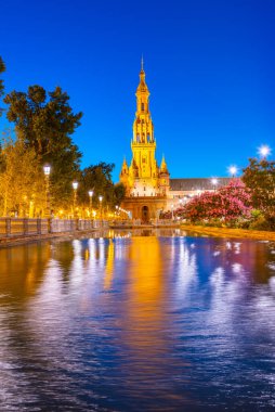 Plaza de Espana, İspanya 'nın Sevilla kentinde gece boyunca suya yansıdı.