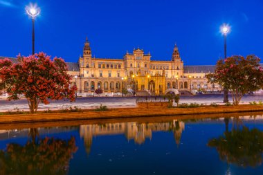 Plaza de Espana, İspanya 'nın Sevilla kentinde gece boyunca suya yansıdı.
