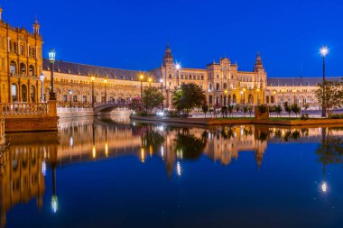 Plaza de Espana, İspanya 'nın Sevilla kentinde gece boyunca suya yansıdı.