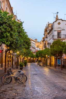 İspanya 'nın eski Sevilla kasabasında güneş doğarken dar bir sokakta.