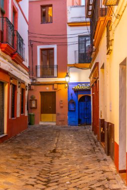 İspanya 'nın eski Sevilla kasabasında güneş doğarken dar bir sokakta.