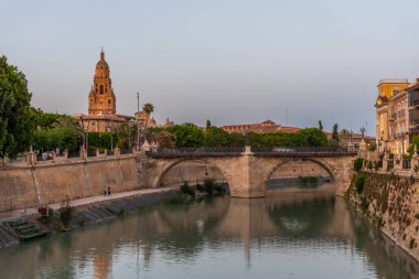 Evening view of riverside of Segura with cathedral and Puente de los peligros in Murcia, Spain clipart