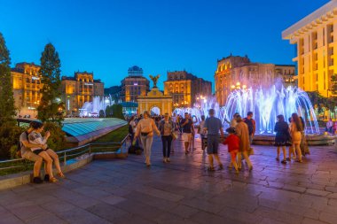 KYIV, UKRAINE, 29 AĞUSTOS 2019: Ukrayna 'nın başkenti Kyiv' deki bağımsızlık meydanında şarkı söyleyen fıskiyenin önünden geçen insanların gece görüntüsü
