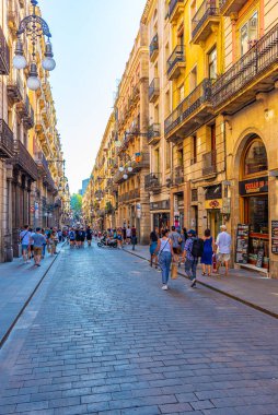 BARCELONA, İspanya, 29 Haziran 2019: İnsanlar İspanya 'nın Barcelona kentindeki dar bir sokaktan geçiyor