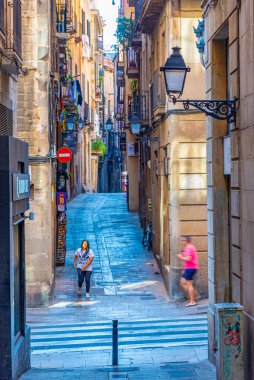 BARCELONA, İspanya, 29 Haziran 2019: İnsanlar İspanya 'nın Barcelona kentindeki dar bir sokaktan geçiyor
