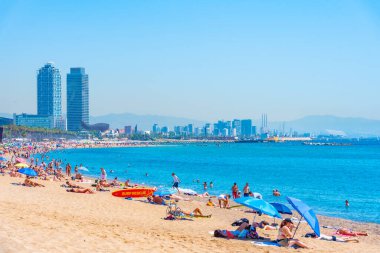 BARCELONA, İspanya, 28 Haziran 2019: Barcelona 'da Barceloneta plajı, arka planda ikiz kuleleri, İspanya