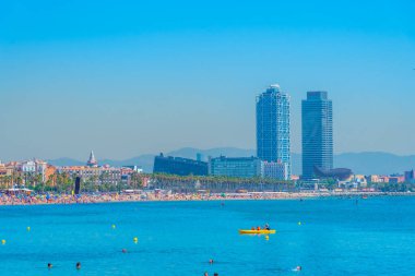 BARCELONA, İspanya, 28 Haziran 2019: Barcelona 'da Barceloneta plajı, arka planda ikiz kuleleri, İspanya