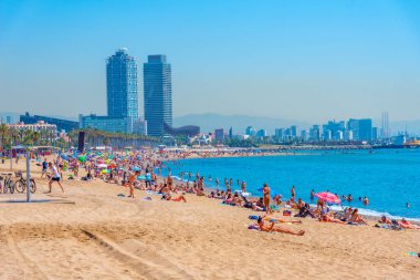 BARCELONA, İspanya, 28 Haziran 2019: Barcelona 'da Barceloneta plajı, arka planda ikiz kuleleri, İspanya