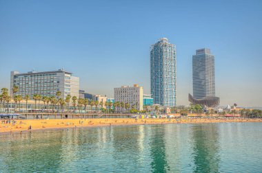 BARCELONA, İspanya, 28 Haziran 2019: Barcelona 'da Barceloneta plajı, arka planda ikiz kuleleri, İspanya