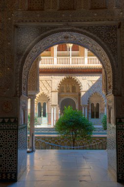 SEVILLA, SPAIN, 25 Haziran 2019: Patio de las Doncellas İspanya 'daki gerçek alcazar de Sevilla' da süslü kapıdan görüldü