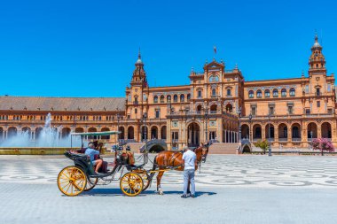 SEVILLA, İspanya, 25 Haziran 2019: Sevilla, İspanya 'daki Plaza de Espana at arabasında turistler