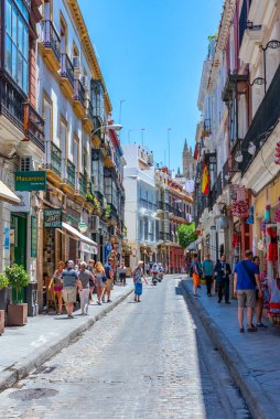 SEVILLA, İspanya, 25 HAZİRAN 2019: İnsanlar Sevilla, İspanya 'da bir sokakta geziniyor