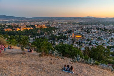 Granada, İspanya, 21 Haziran 2019: İnsanlar İspanya 'nın Sacromonte tepesinden Granada üzerinde günbatımının tadını çıkarıyorlar.