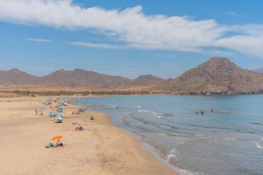 SAN JOSE, İspanya, 21 Haziran 2019: İnsanlar İspanya Cabo de Gata 'daki Playa de los Genoveses plajında güneşli bir günün tadını çıkarıyorlar