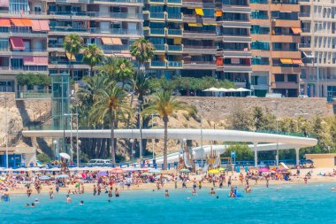 ALICANTE, İspanya, 18 Haziran 2019: İnsanlar İspanya 'nın Alicante kentindeki Postiguet plajında güneşli bir günün tadını çıkarıyorlar