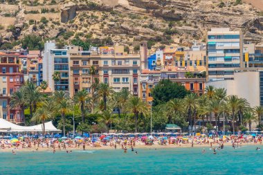 ALICANTE, İspanya, 18 Haziran 2019: İnsanlar İspanya 'nın Alicante kentindeki Postiguet plajında güneşli bir günün tadını çıkarıyorlar