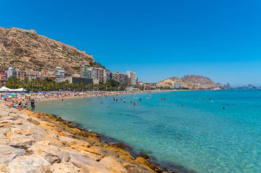 ALICANTE, İspanya, 18 Haziran 2019: İnsanlar İspanya 'nın Alicante kentindeki Postiguet plajında güneşli bir günün tadını çıkarıyorlar