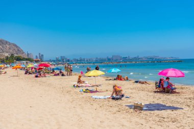 ALICANTE, İspanya, 18 Haziran 2019: İnsanlar İspanya 'nın Alicante kentindeki Postiguet plajında güneşli bir günün tadını çıkarıyorlar