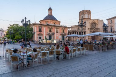 VALENCIA, SPAIN, 17 Haziran 2019: Valencia 'daki Basilica de la Virgen de los Desamparados ve Katedral' in günbatımı Plaza de la Virgen, İspanya