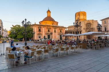 VALENCIA, SPAIN, 17 Haziran 2019: Valencia 'daki Basilica de la Virgen de los Desamparados ve Katedral' in günbatımı Plaza de la Virgen, İspanya