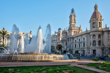 VALENCIA, İspanya, 17 Haziran 2019 İspanya 'nın Valencia kentindeki bir çeşmenin arkasında halk belediye binasının önünden geçiyor.