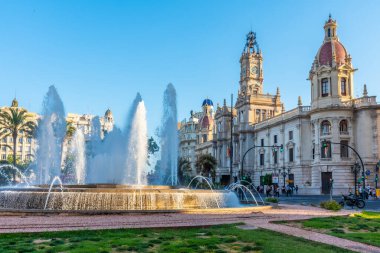 VALENCIA, İspanya, 17 Haziran 2019 İspanya 'nın Valencia kentindeki bir çeşmenin arkasında halk belediye binasının önünden geçiyor.