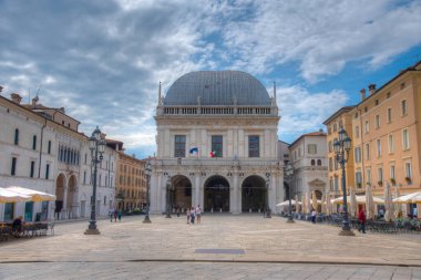 BRESCIA, İtalya, 15 Temmuz 2019 İnsanlar İtalya 'daki Palazzo della Loggia ile Brescia' nın merkezinden geçiyorlar.