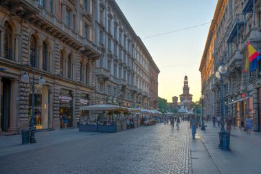 MILANO, ITALY, 19 Temmuz 2019: Milano, İtalya 'da Castello Sforzesco' ya doğru Dante Via 'da gezinen insanların günbatımı