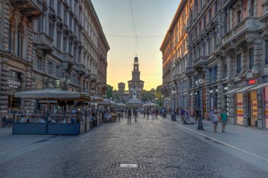 MILANO, ITALY, 19 Temmuz 2019: Milano, İtalya 'da Castello Sforzesco' ya doğru Dante Via 'da gezinen insanların günbatımı