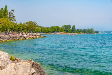 DESENZANO DEL GARDA, İTALYA, 21 Temmuz 2019: İnsanlar İtalya 'nın Desenzano del Garda plajında güneşli bir günün tadını çıkarıyorlar
