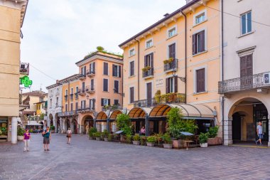 DESENZANO DEL GARDA, ITALY, JULY 22, 2019: People are strolling at Piazza Giuseppe Malvezzi in Desenzano del Garda in Italy clipart