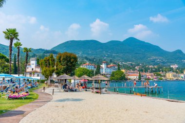 GARDON RIVIERA, ITALY, 23 Temmuz 2019: İnsanlar İtalya 'da Lago di Garda' da bulunan Gardone Riviera plajında güneşli bir günün tadını çıkarıyorlar