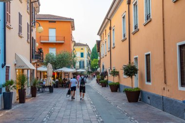 DESENZANO DEL GARDA, ITALY, 23 Temmuz 2019: İnsanlar İtalya 'da Desenzano del Garda' da bir sokakta geziniyor