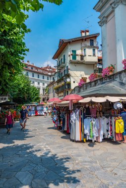 ISOLA BELLA, İtalya, 25 Temmuz 2019: İnsanlar Isola Bella 'da Isola Maggiore, İtalya' da dar bir sokakta yürüyorlar