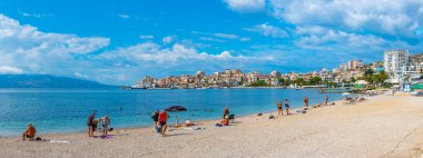 SARANDE, ALBANIA, 24 EYLÜL 2019: İnsanlar Arnavutların Sarande plajında güneşli bir günün tadını çıkarıyorlar