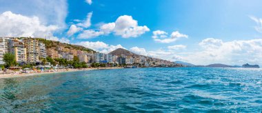 SARANDE, ALBANIA, 24 EYLÜL 2019: İnsanlar Arnavutların Sarande plajında güneşli bir günün tadını çıkarıyorlar