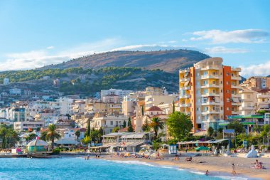 SARANDE, ALBANIA, 24 EYLÜL 2019: İnsanlar Arnavutluk 'un Sarande kentindeki plajda güneşli bir günün tadını çıkarıyorlar